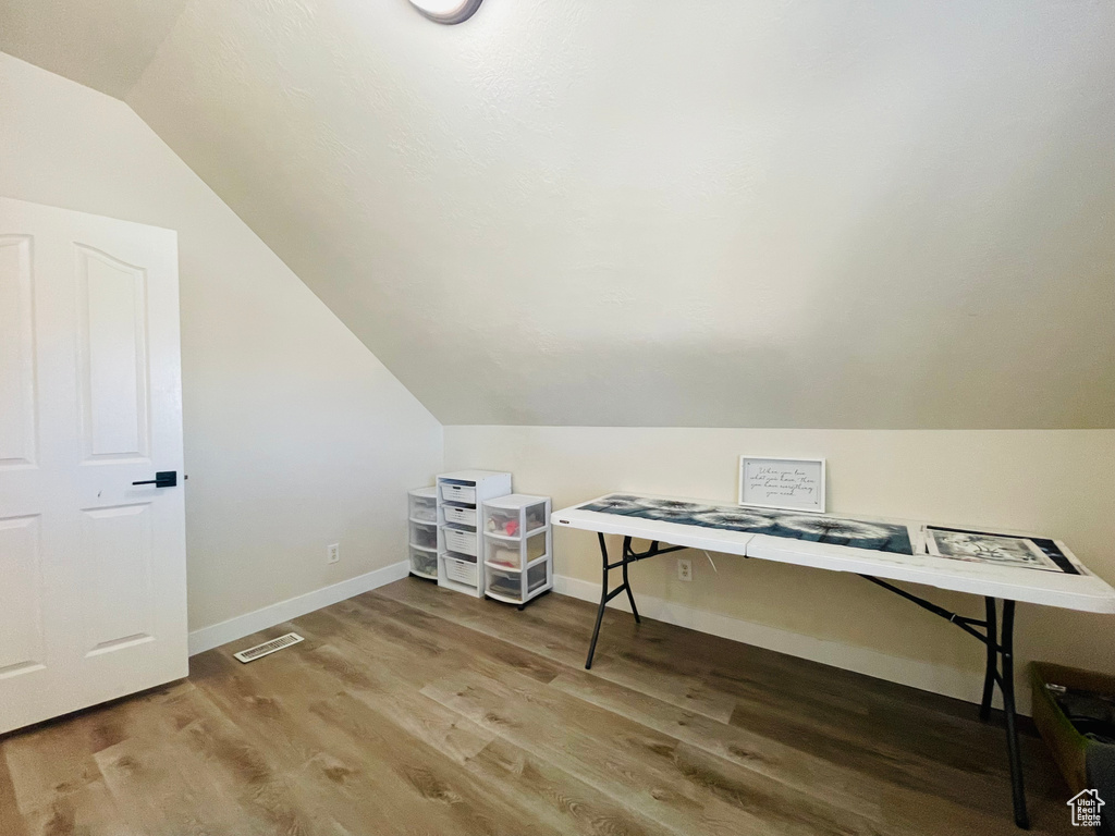 Office area with hardwood / wood-style flooring and lofted ceiling