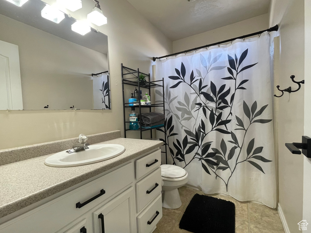 Bathroom featuring tile patterned flooring, vanity, and toilet