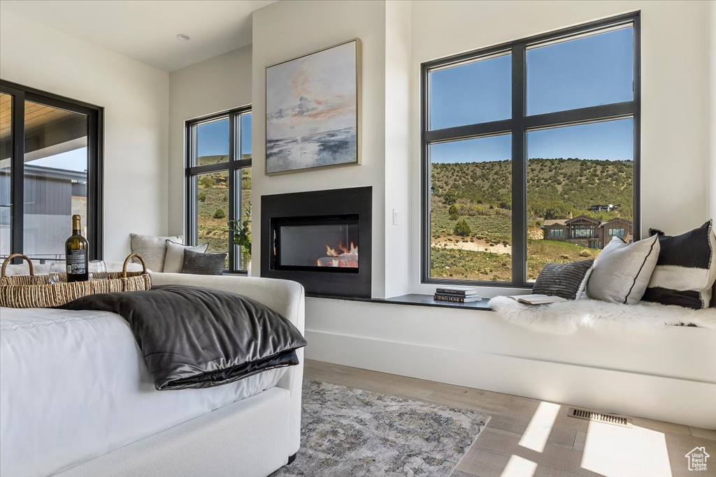 Living room with wood finished floors and a glass covered fireplace
