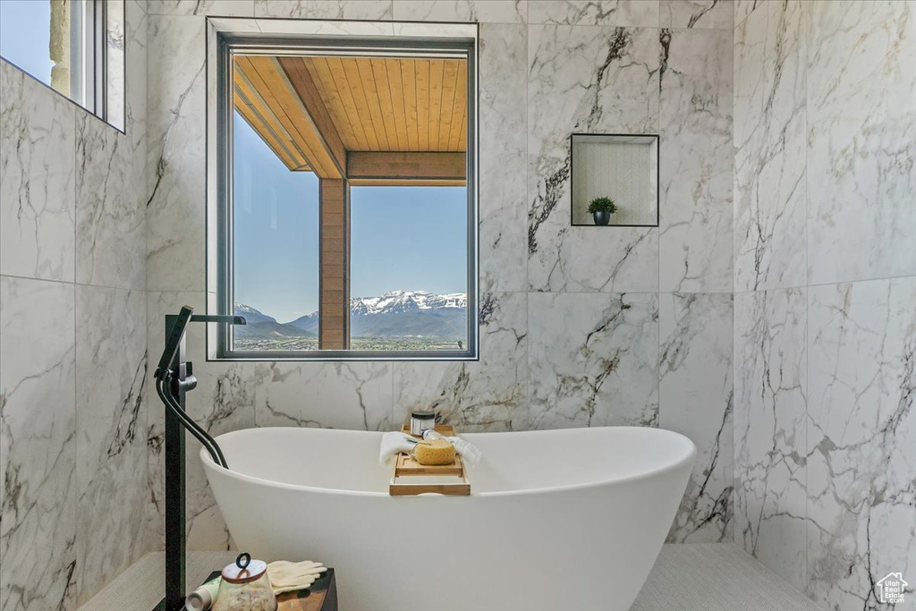 Full bathroom with tile walls and a freestanding bath