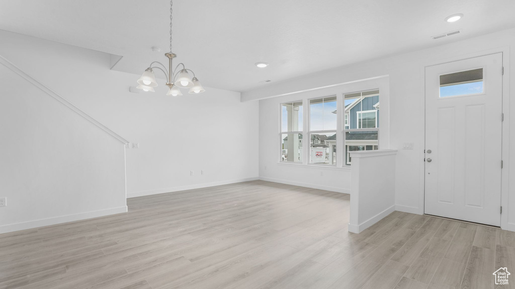 Entrance foyer with light wood-style flooring, a chandelier, baseboards, and recessed lighting