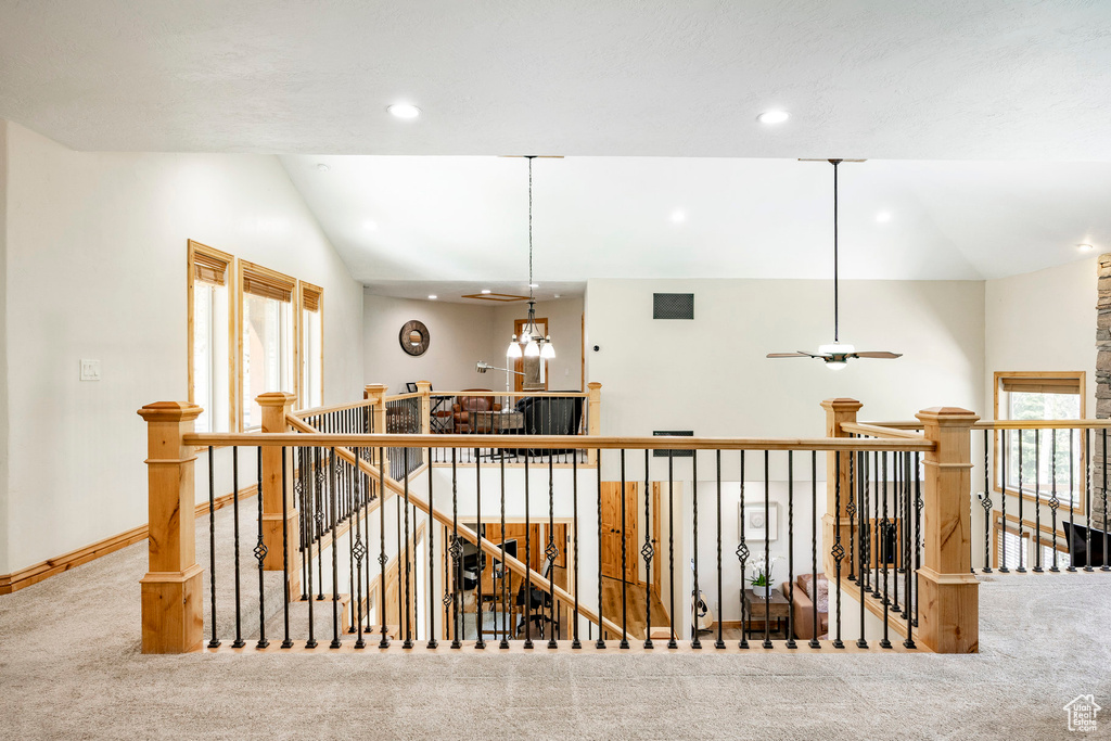 Corridor with an upstairs landing, carpet flooring, vaulted ceiling, recessed lighting, and baseboards