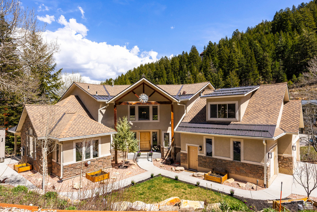 Back of property with stone siding and stucco siding