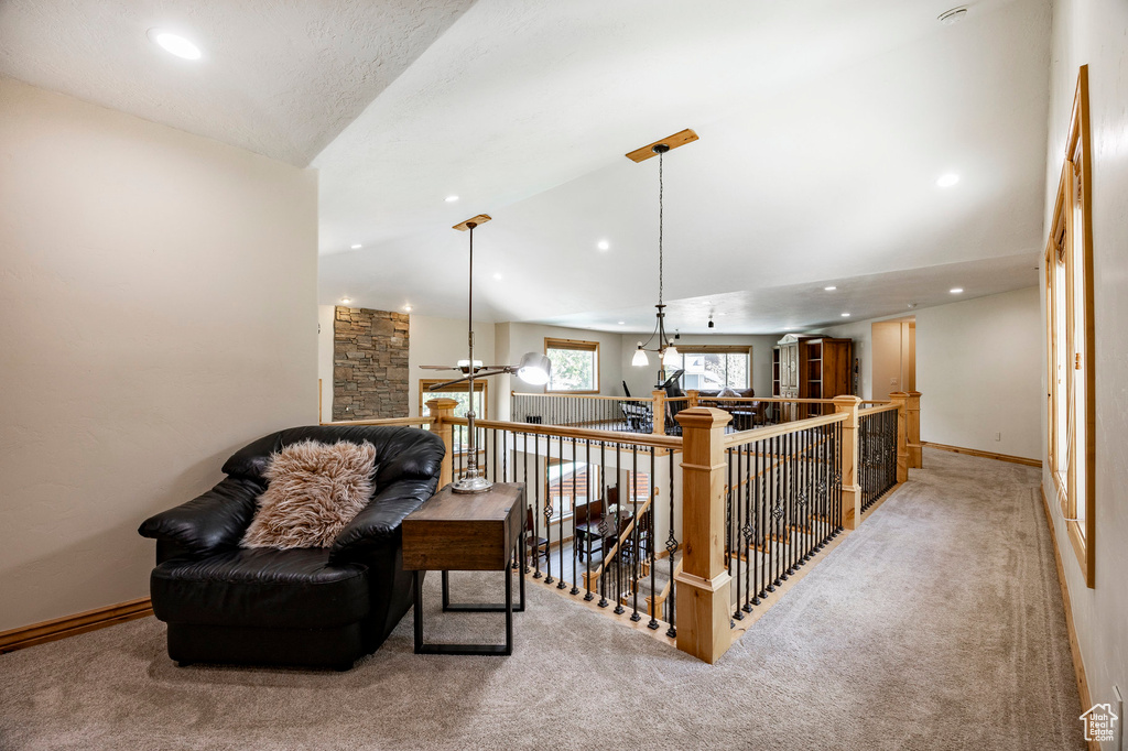 Living area featuring carpet, lofted ceiling, an upstairs landing, recessed lighting, and baseboards