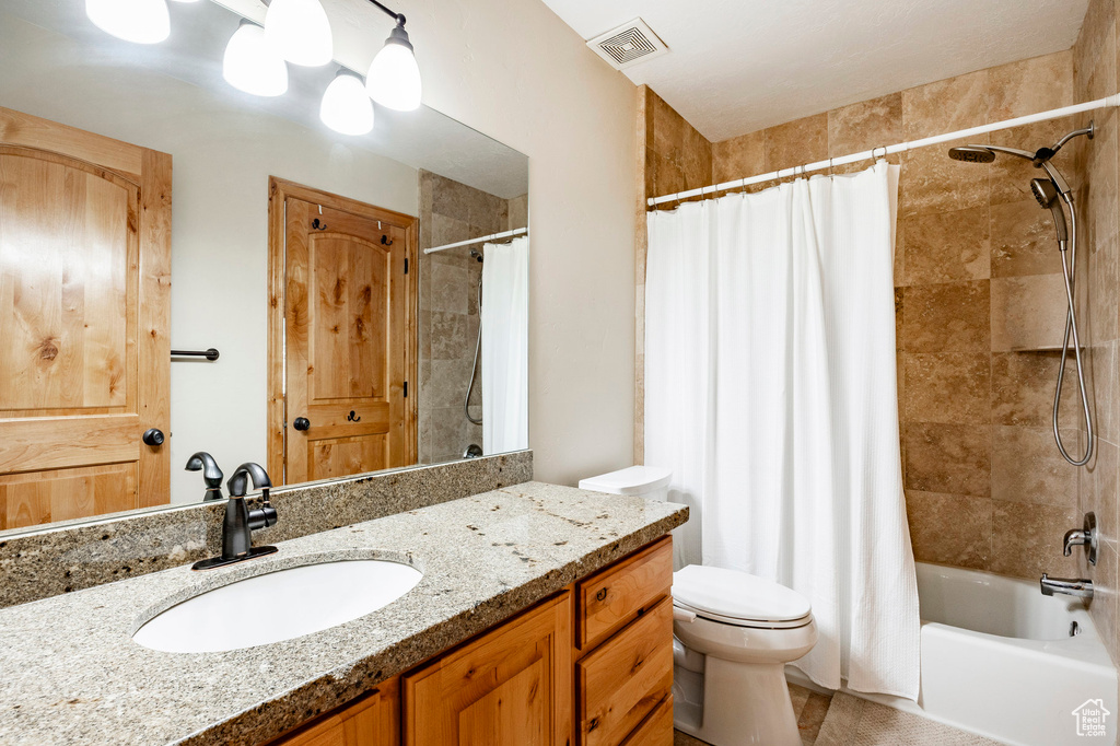 Bathroom featuring shower / tub combo, vanity, and toilet