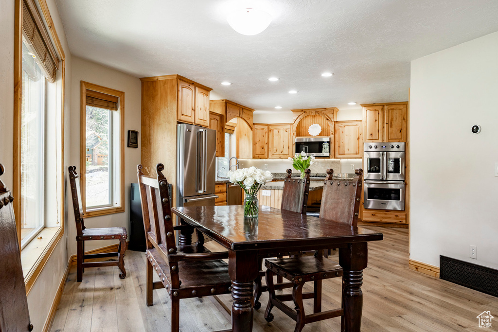 Dining area with baseboards, light wood-type flooring, and recessed lighting