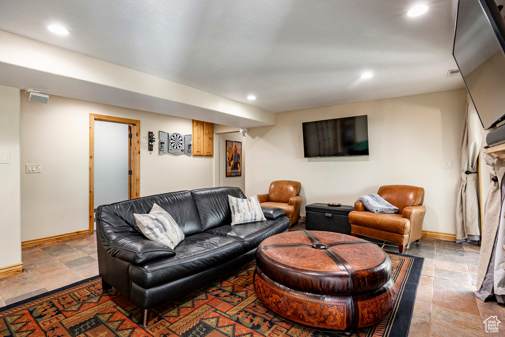 Living area with stone tile floors, recessed lighting, and baseboards