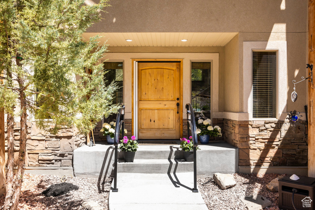 Property entrance featuring stone siding and stucco siding
