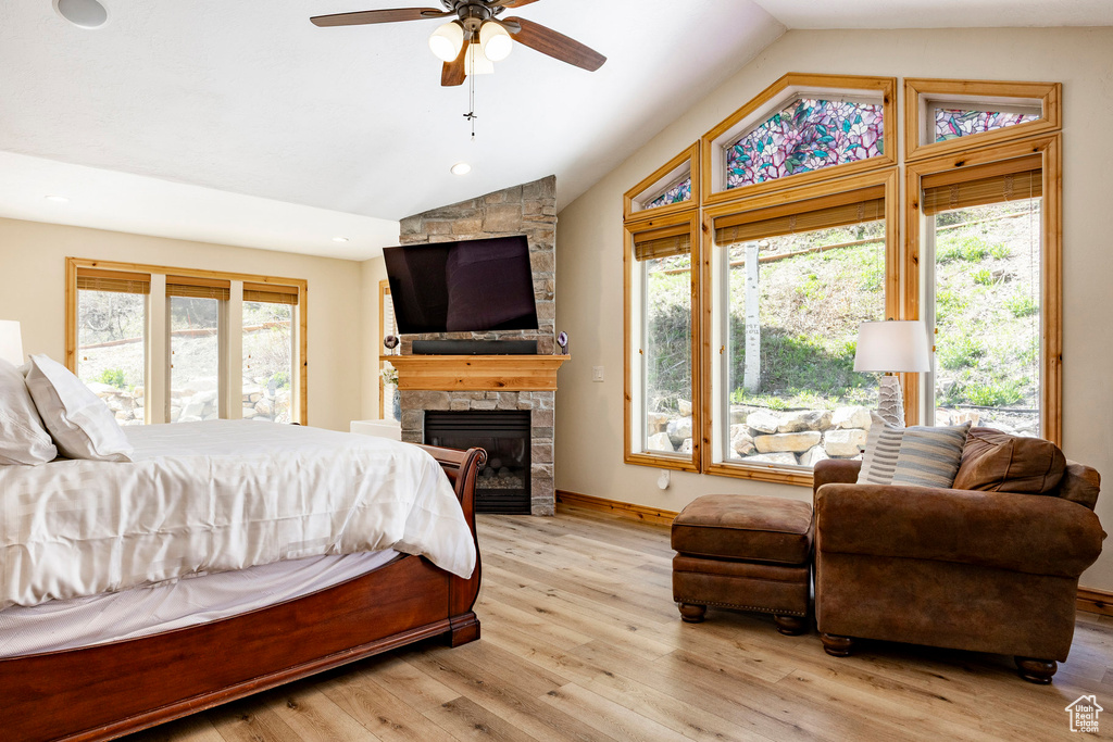 Bedroom with lofted ceiling, a fireplace, light wood finished floors, baseboards, and recessed lighting
