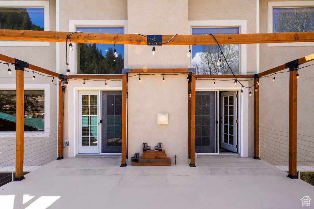 Property entrance with stucco siding and a patio