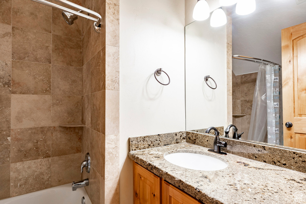 Bathroom with shower / tub combo with curtain and vanity