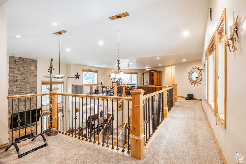 Hall featuring recessed lighting, light colored carpet, an upstairs landing, baseboards, and a towering ceiling