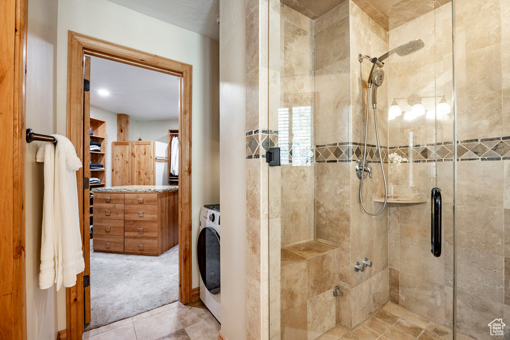 Full bath with a stall shower and washer / dryer