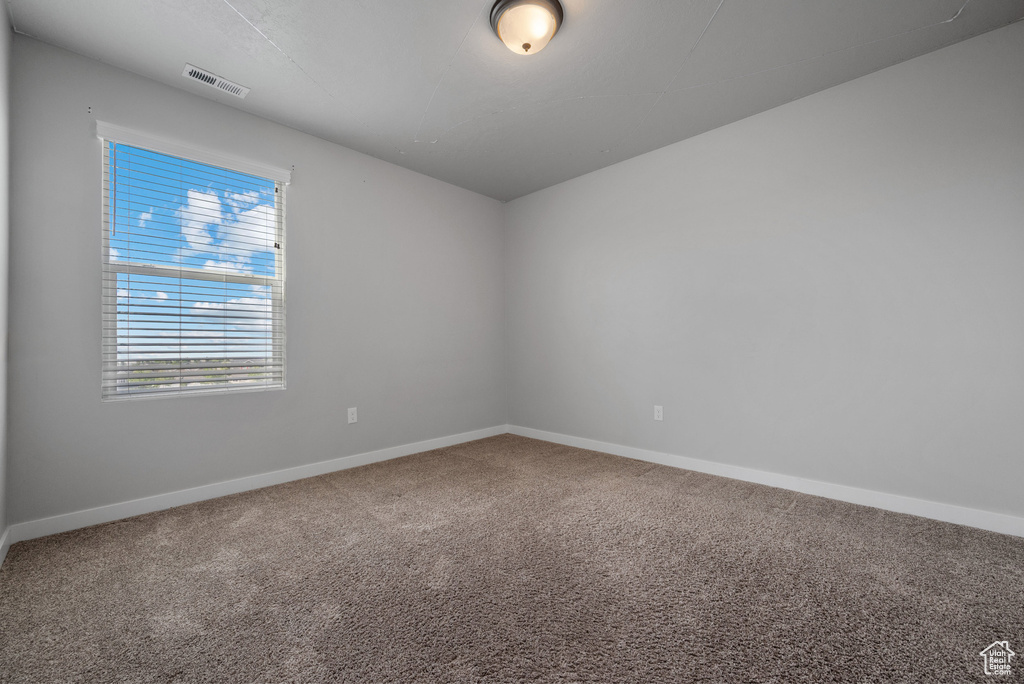Carpeted empty room featuring baseboards