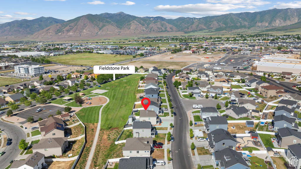Aerial view of property and surrounding area featuring a mountainous background and nearby suburban area