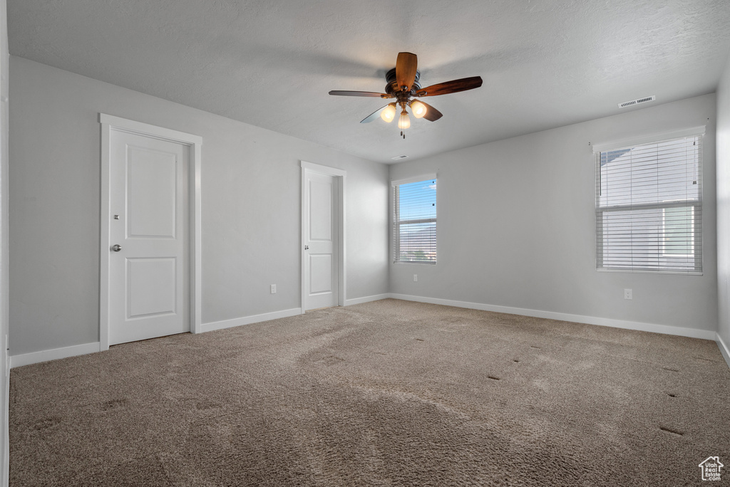 Unfurnished bedroom featuring carpet flooring, baseboards, and ceiling fan