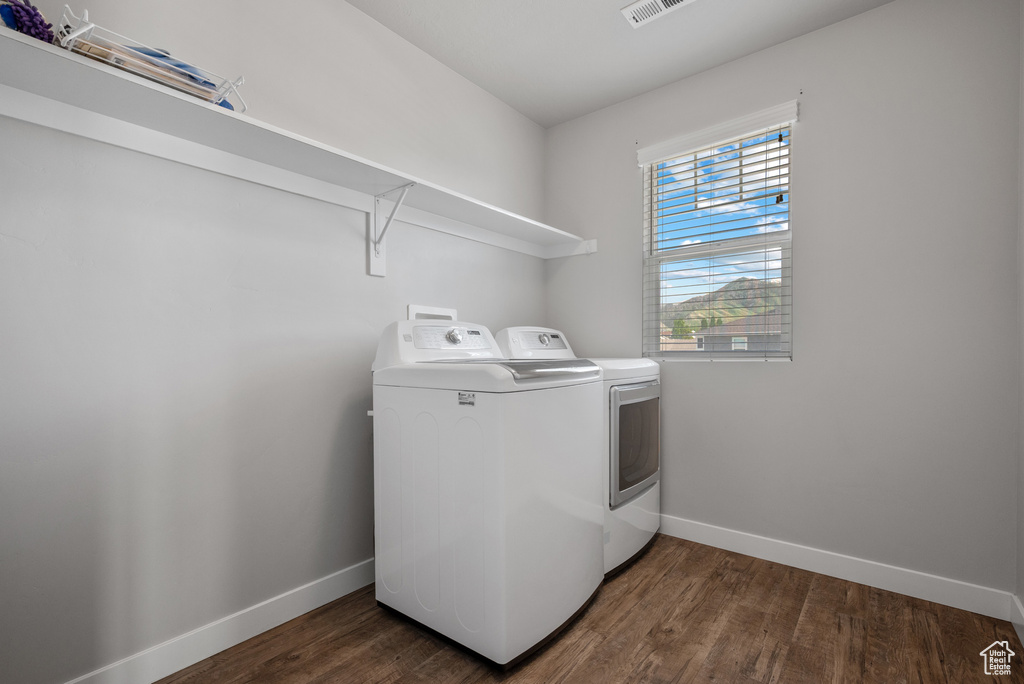 Laundry area featuring washer and clothes dryer, baseboards, and wood finished floors