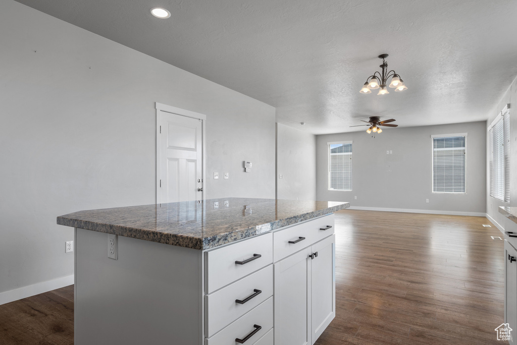 Kitchen featuring a chandelier, ceiling fan, a kitchen island, baseboards, and recessed lighting
