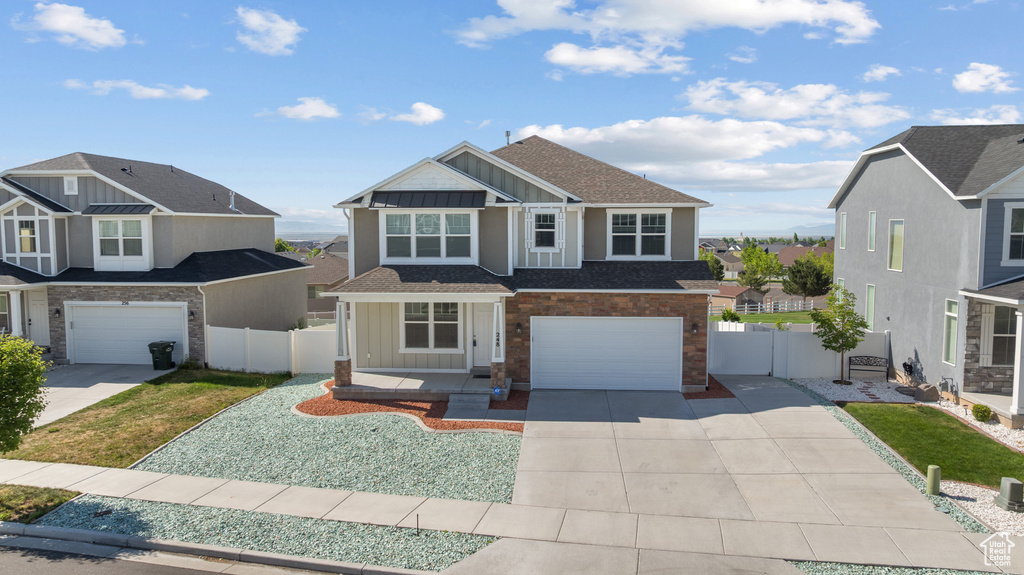 View of front of property featuring board and batten siding, driveway, a garage, and a shingled roof