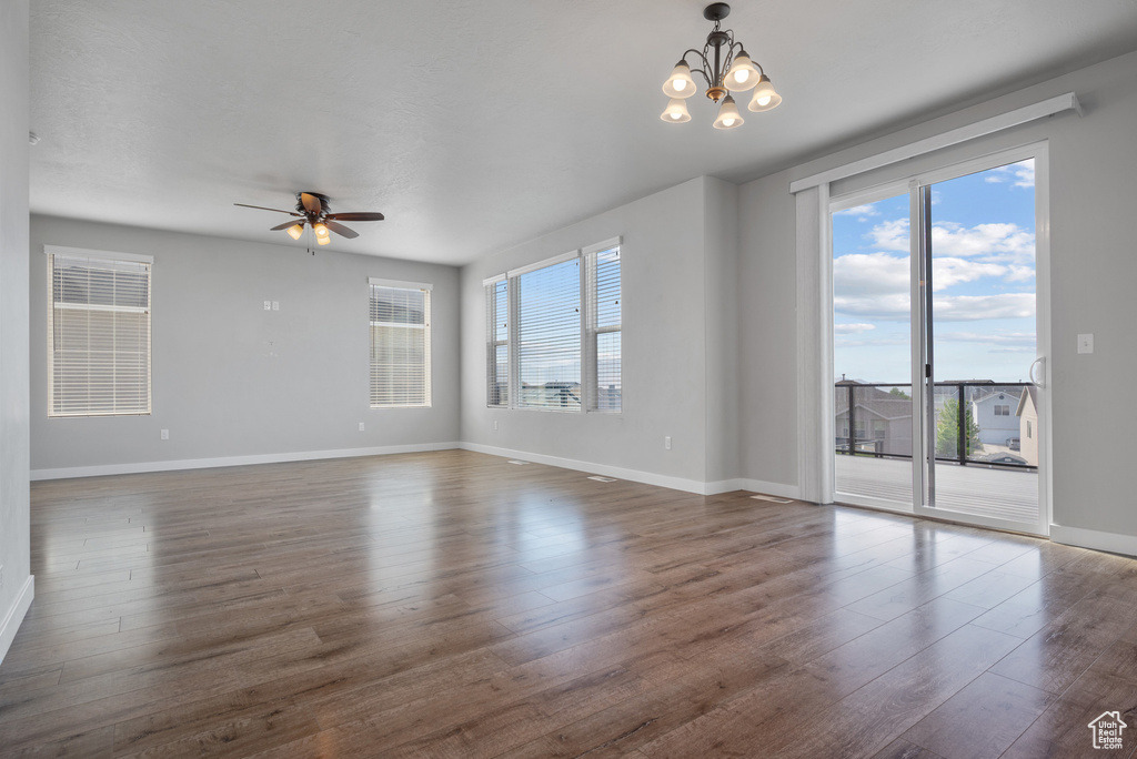 Unfurnished room with plenty of natural light, dark wood-style floors, baseboards, and a ceiling fan