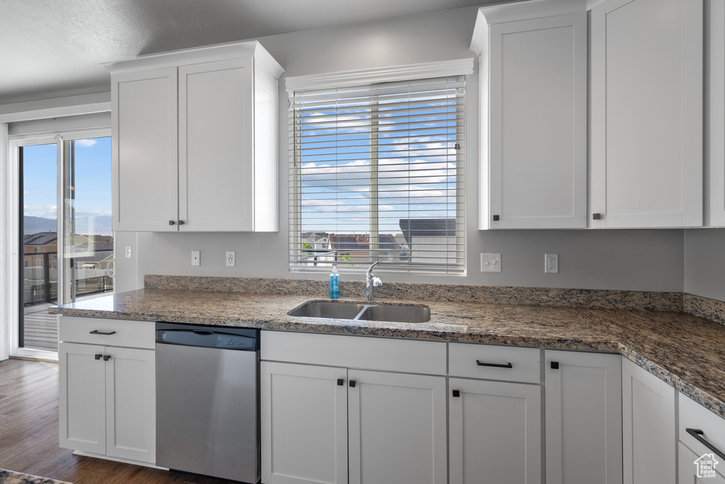 Kitchen with dishwasher, a sink, white cabinets, and healthy amount of natural light