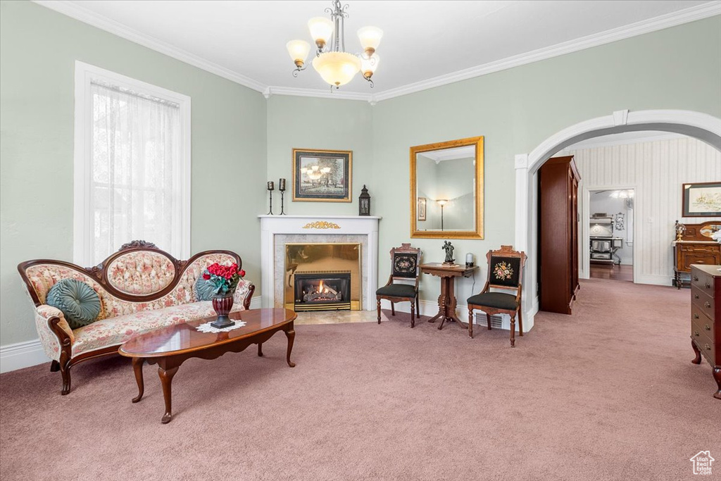 Living area featuring an inviting chandelier, light colored carpet, and ornamental molding