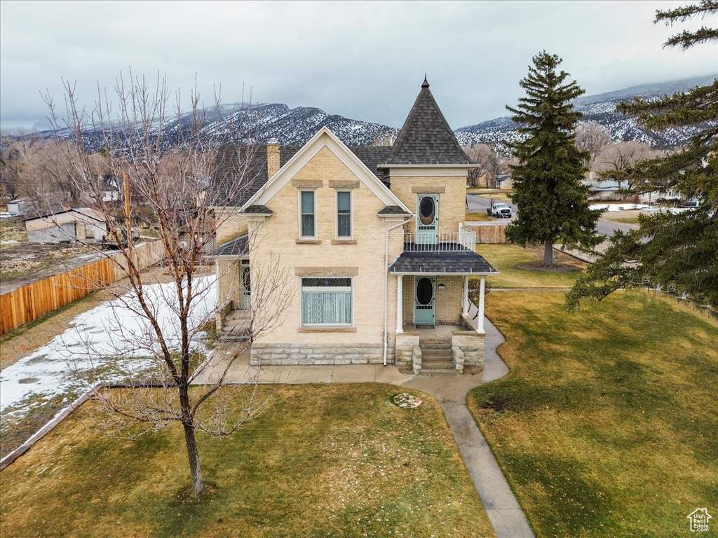 View of front of home with a mountain view and a front yard