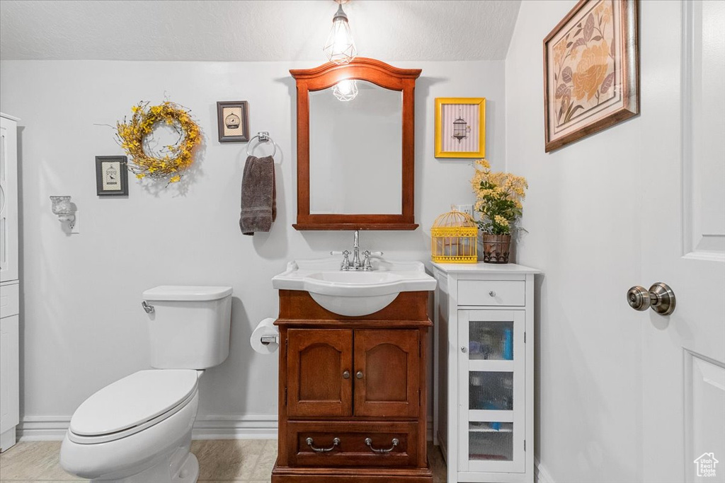 Bathroom featuring a textured ceiling, vanity, toilet, and tile patterned floors