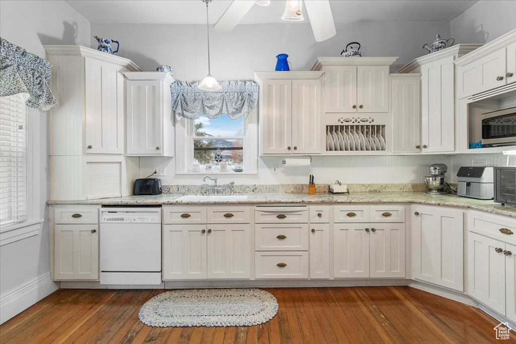 Kitchen with plenty of natural light, sink, white dishwasher, and decorative light fixtures