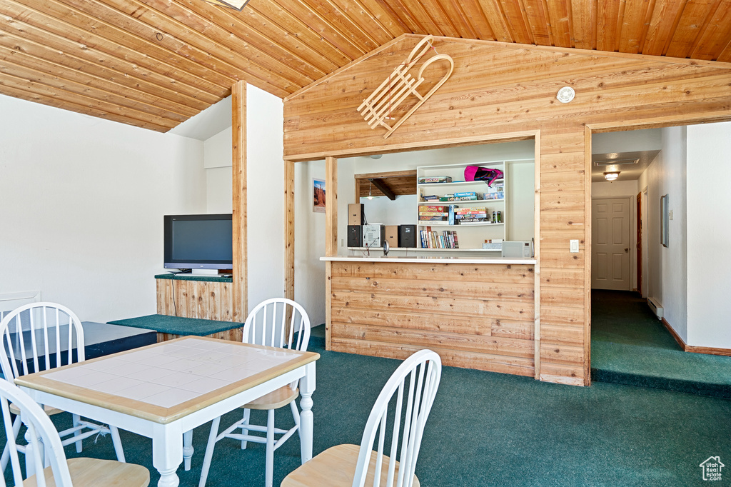 Carpeted dining space featuring lofted ceiling and wood ceiling