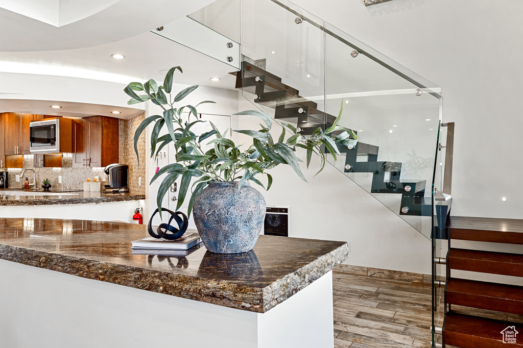 Interior space with a sink, wood finished floors, and recessed lighting