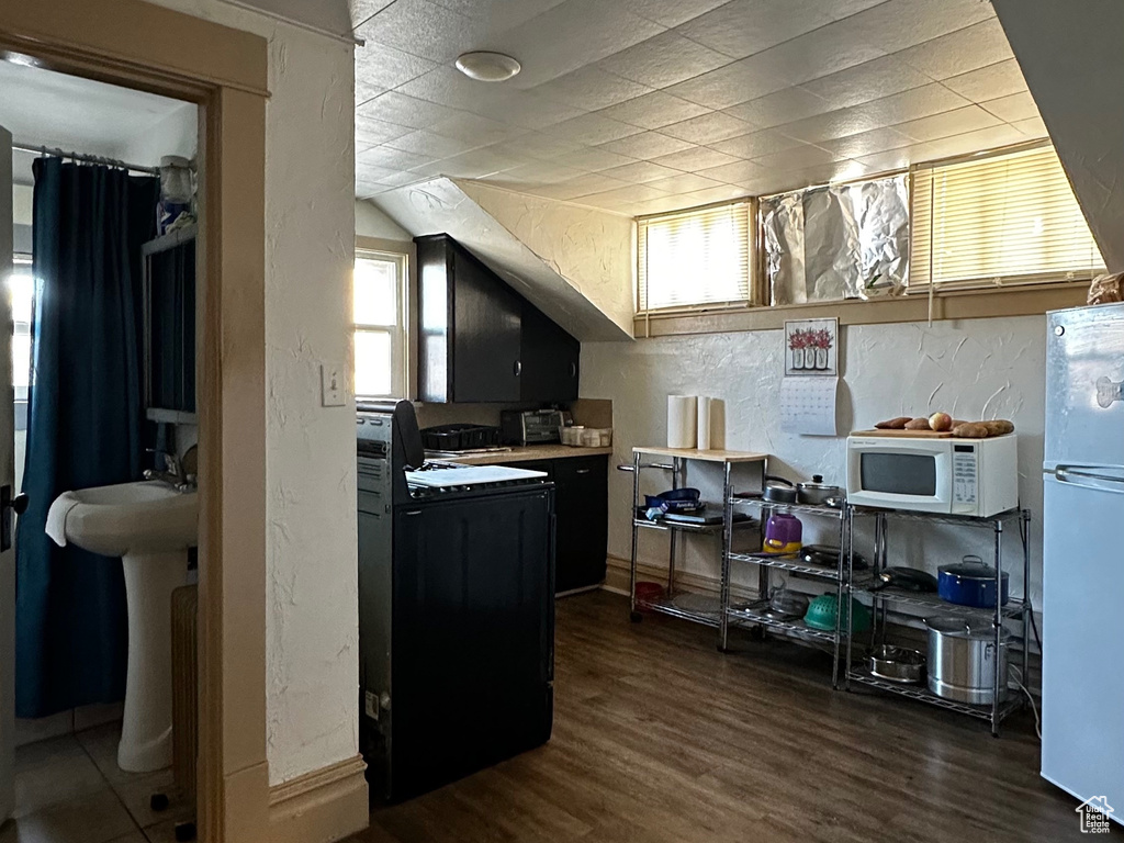 Kitchen with dark hardwood / wood-style flooring and white appliances