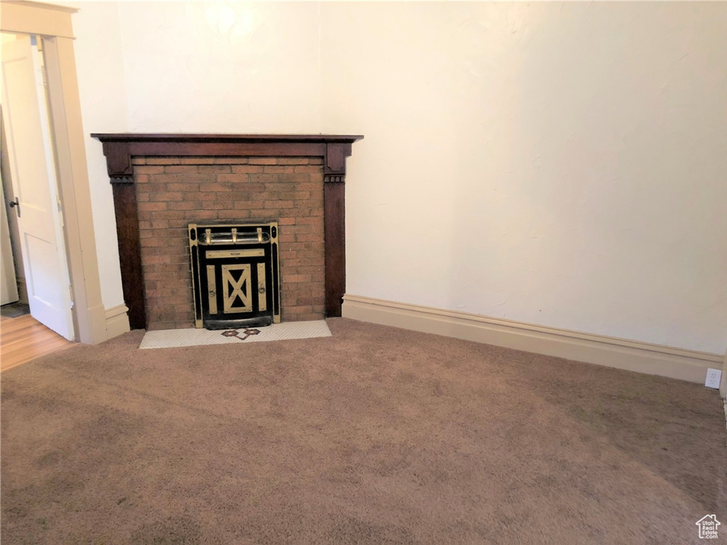 Room details featuring a fireplace and carpet