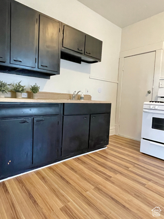 Kitchen featuring electric stove, sink, and light hardwood / wood-style floors