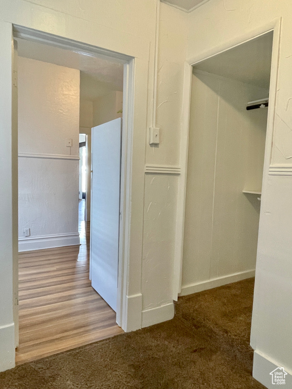 Hallway featuring dark colored carpet