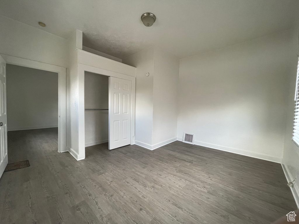 Unfurnished bedroom featuring dark wood-type flooring