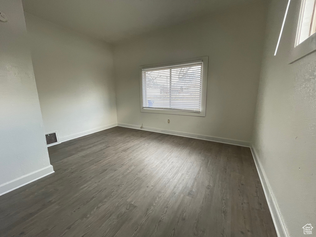 Spare room featuring dark wood-type flooring