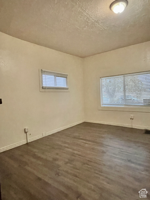 Spare room with dark wood-type flooring