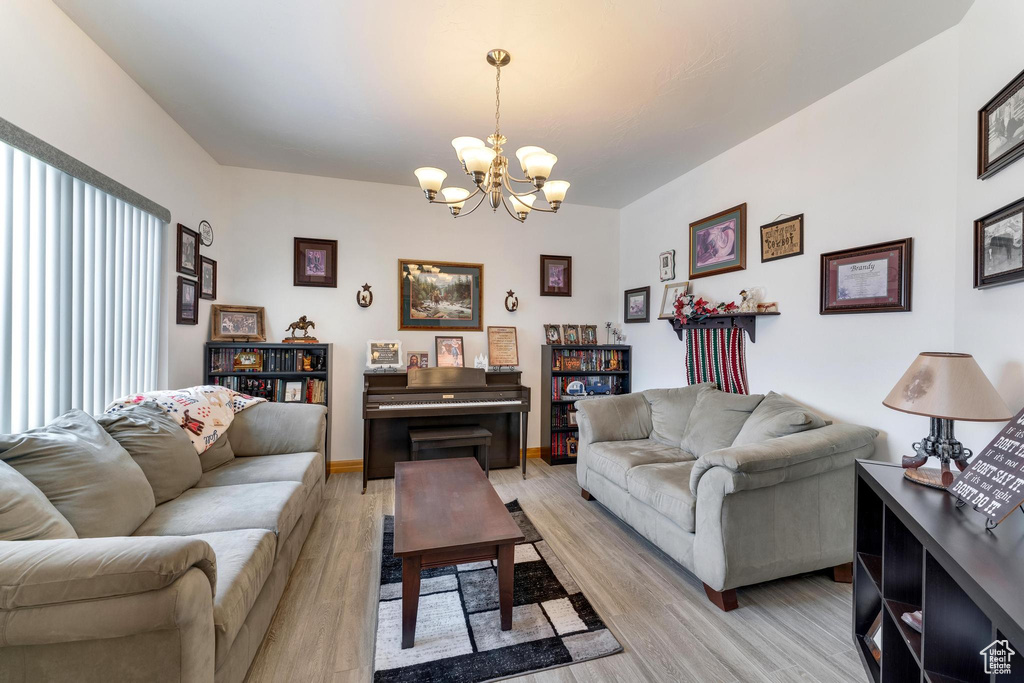Living room featuring a notable chandelier and light wood-type flooring