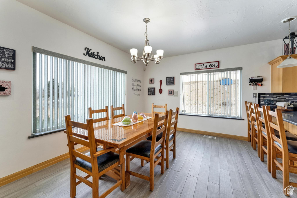 Dining room with hardwood / wood-style flooring and a notable chandelier