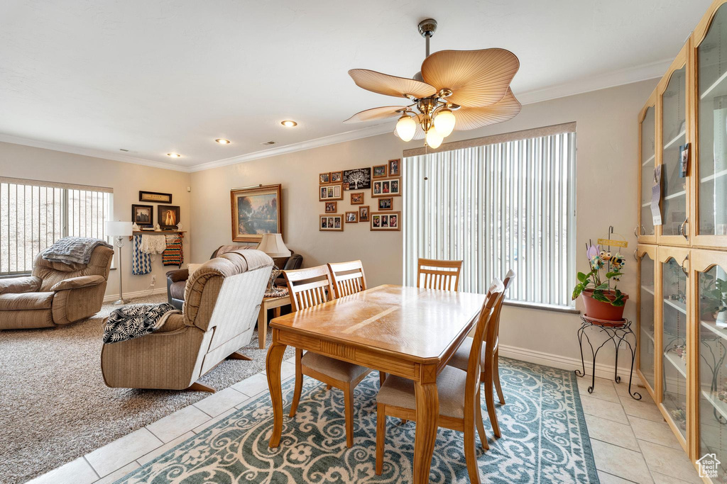 Tiled dining area with ceiling fan and crown molding