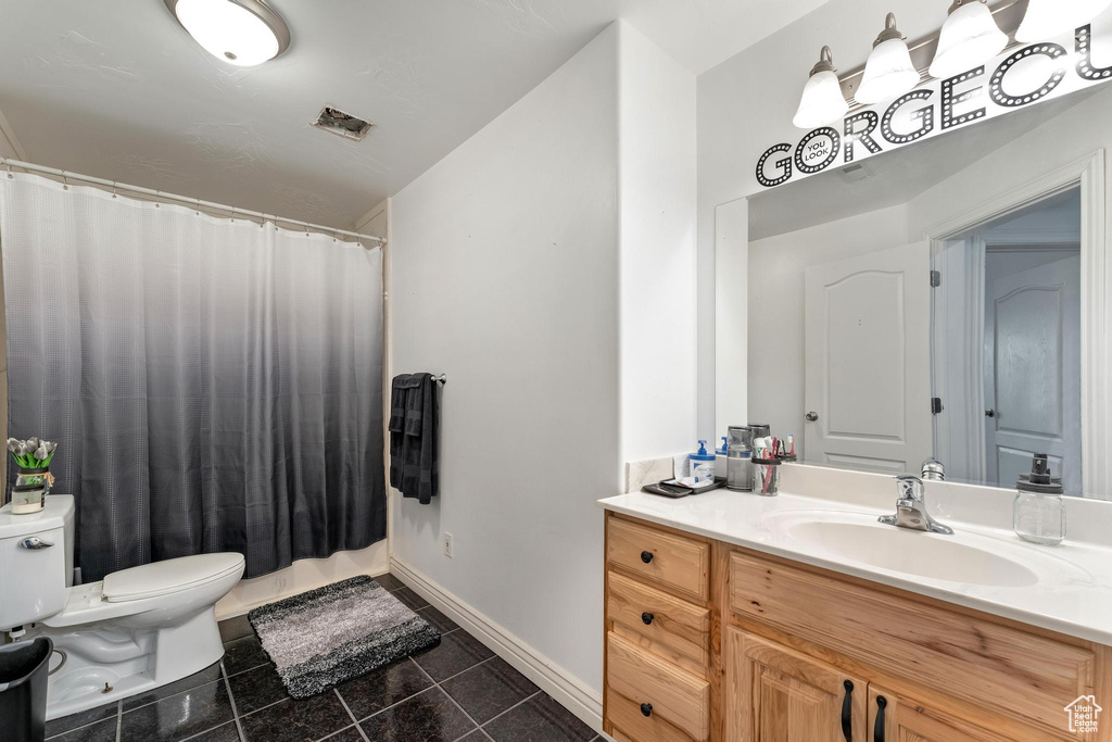 Bathroom with a shower with curtain, vanity, and toilet