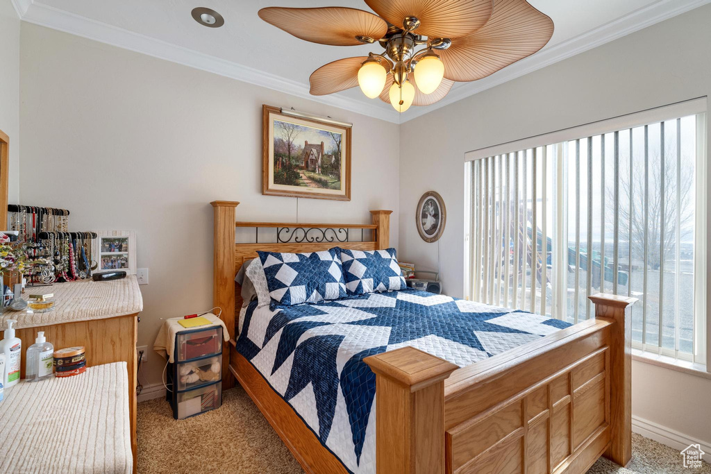 Bedroom with ceiling fan, light colored carpet, and multiple windows