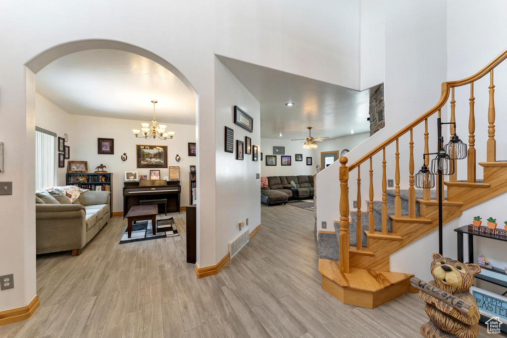 Interior space featuring ceiling fan with notable chandelier and light hardwood / wood-style flooring