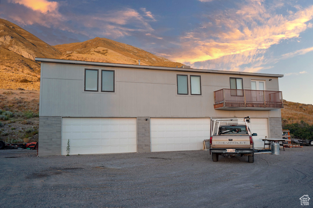 View of front of property with a mountain view, a balcony, and a garage