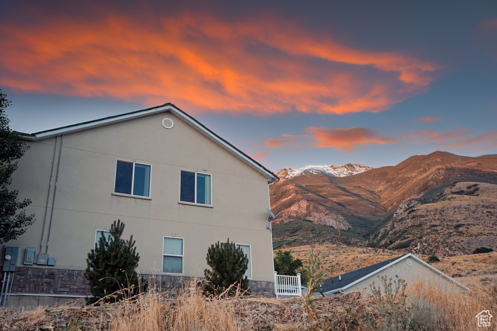 Property exterior at dusk featuring a mountain view