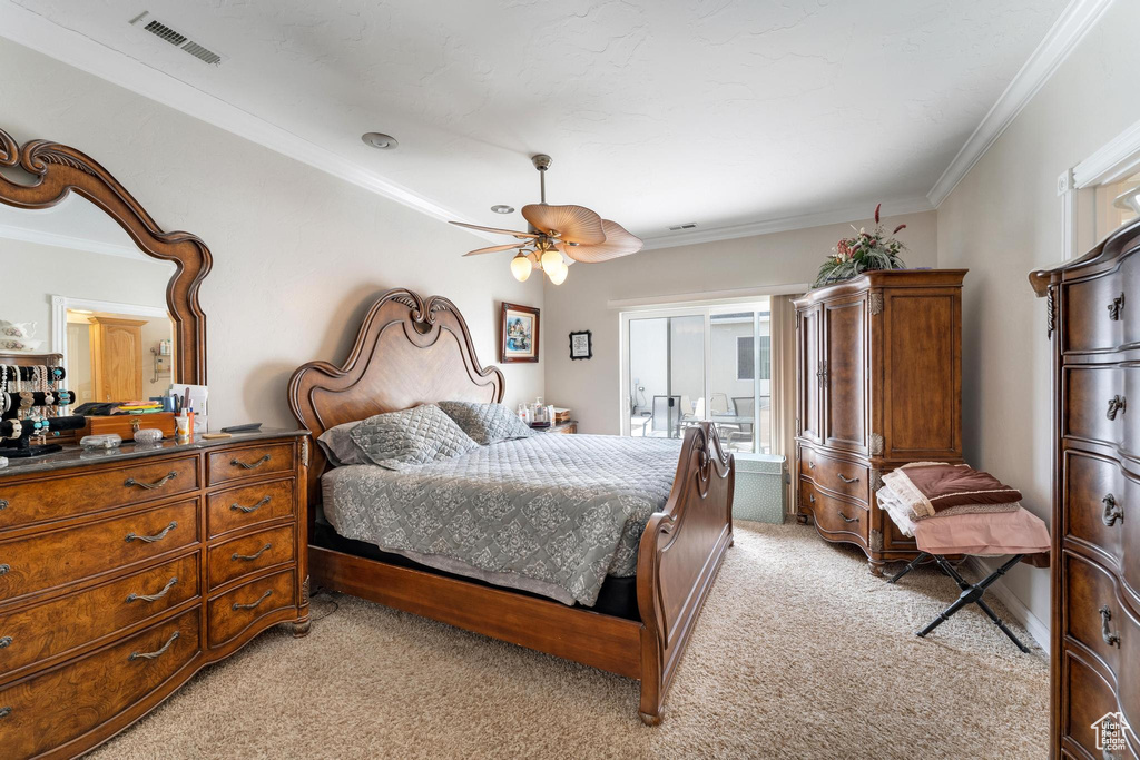 Bedroom with ceiling fan, light colored carpet, and crown molding