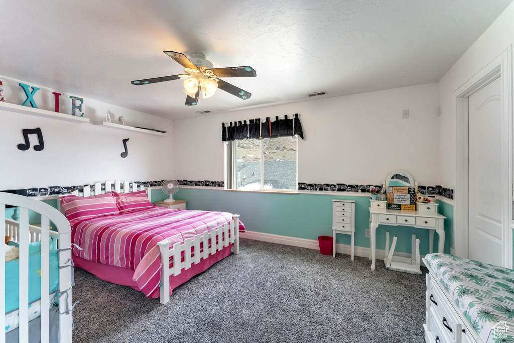 Bedroom featuring dark colored carpet and ceiling fan