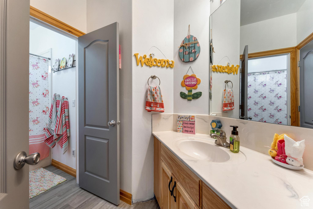 Bathroom featuring hardwood / wood-style floors, vanity, and a shower with shower curtain