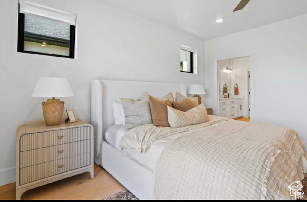 Bedroom with connected bathroom, ceiling fan, and light hardwood / wood-style flooring